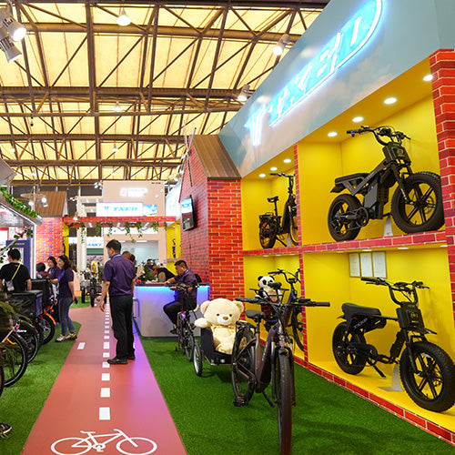 Visitors exploring the TXED electric bike exhibition stand.
