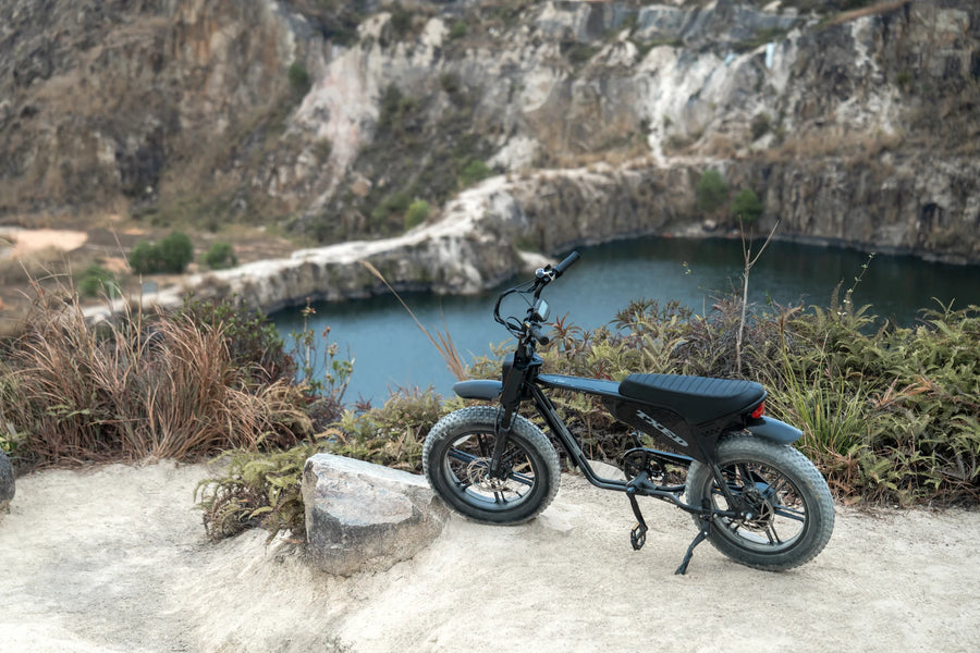 A TXED Maverick parked on a rocky path overlooking a lake.